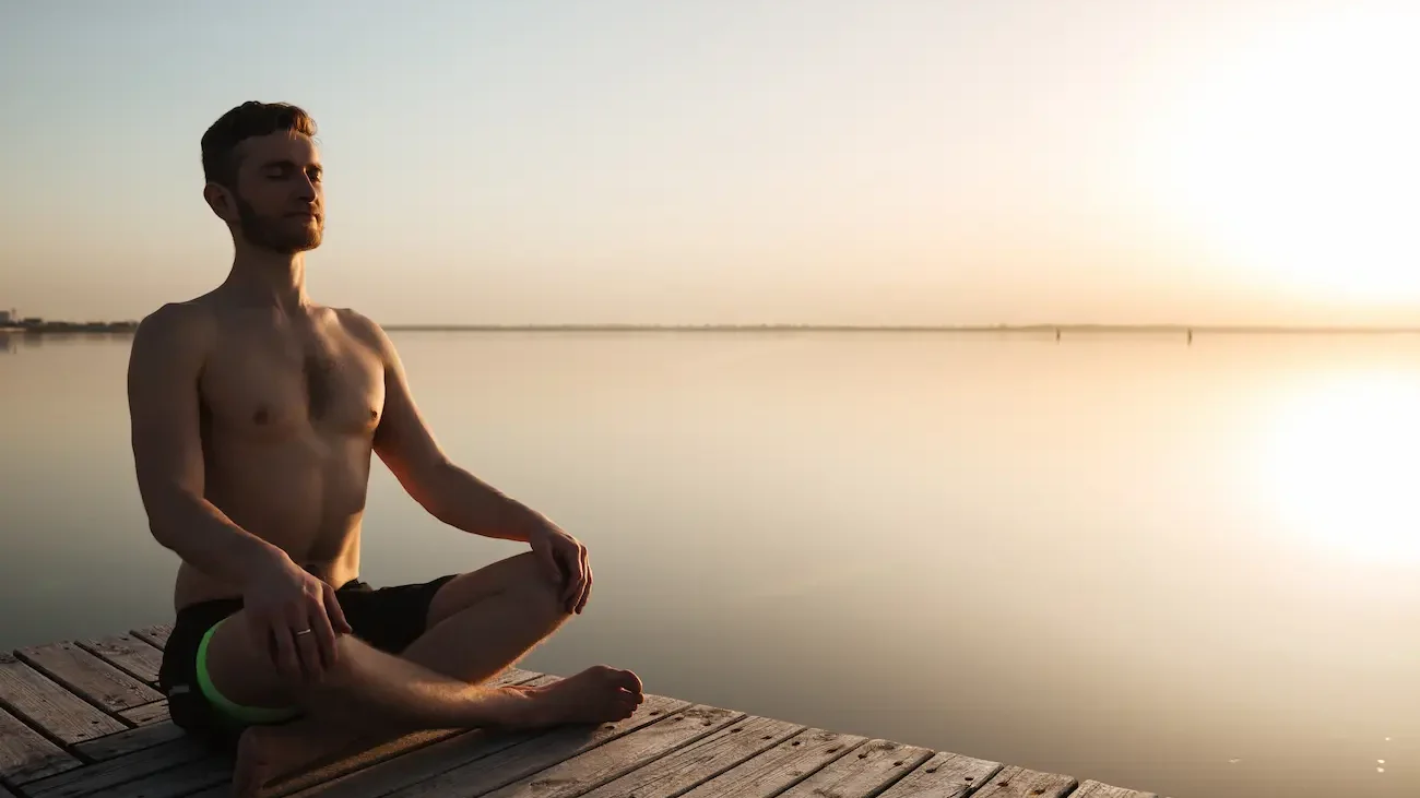 hombre meditando en la playa